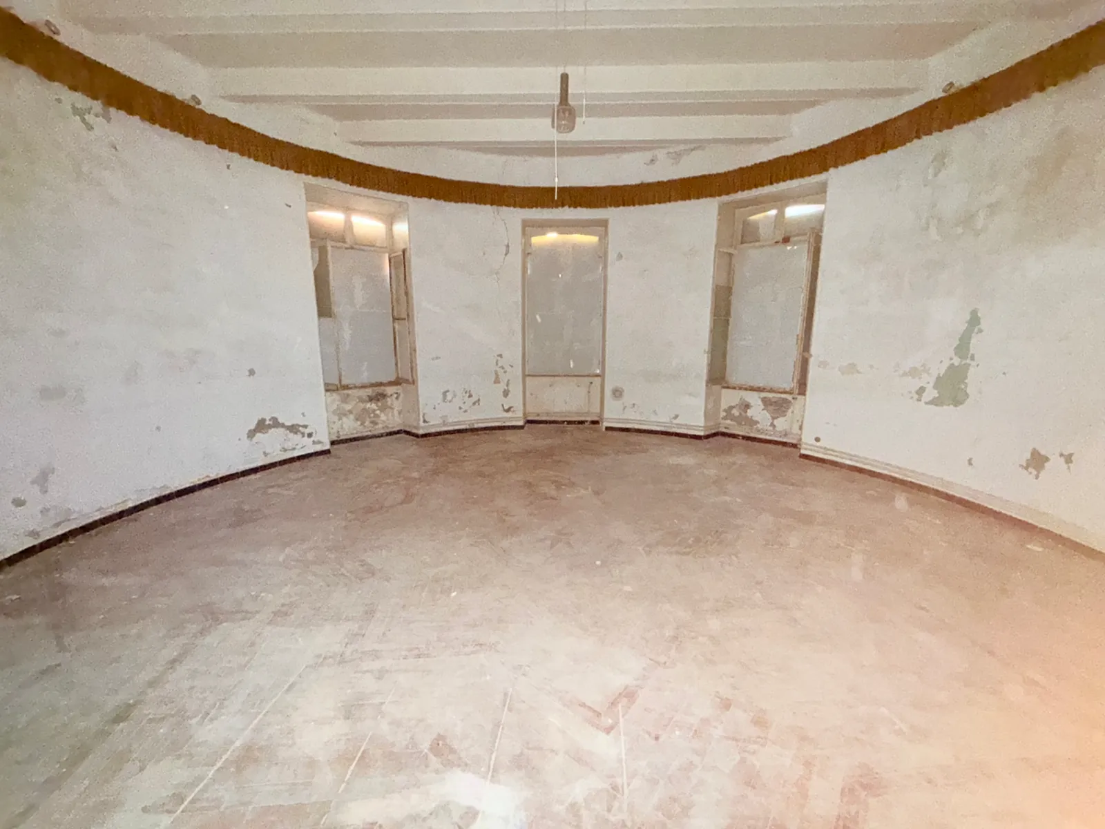 Séjour arrondi du lot 0.04 du château des Bormettes avant restauration, trois fenêtres et plafond à poutres