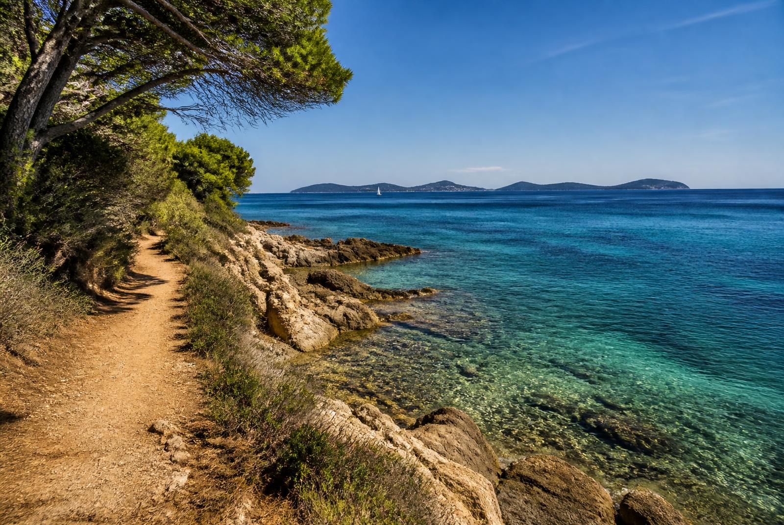 Sentier du littoral entre rochers et eaux turquoise, face aux îles d'Or